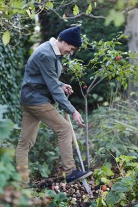 a man digging in a garden: Planting flowerbulbs